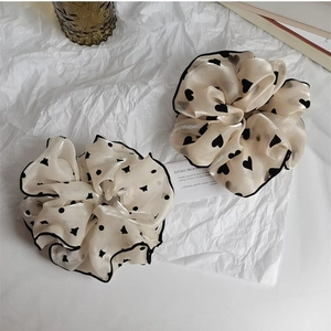 Détail de chouchous en organza crème avec imprimés de cœurs et de papillons