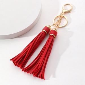 Close-up of red leather double tassel keychain with elegant gold-plated hardware and clasp