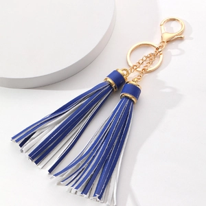 Detail of dual tassel keychain in royal blue and white with golden metal ring and clasp