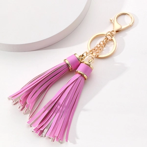 Detail of pink PU leather double tassel keychain with golden metal clasp and rings