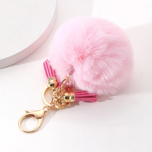 Détail du porte-clés pompon en fourrure rose avec doubles glands et fermoir doré chic