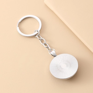 Silver metal tiger glass gem keychain with circular pendant and detailed sunburst texture