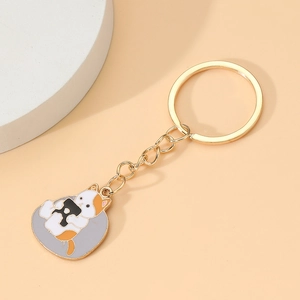 Porte-clés chat tricolore mignon avec lettre R dorée sur fond beige minimaliste