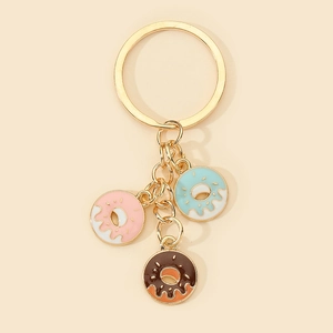 Close-up of golden metal keyring featuring three colorful enamel donut pendants