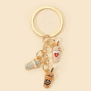 Detail of gold metal keychain with three colorful enamel milk tea cup charms and heart patterns