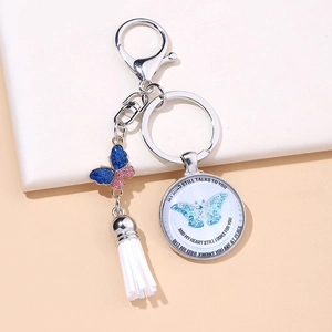 Detail view of butterfly glass pendant with white tassel and silver keychain