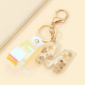 Detail of resin letter M keychain featuring sea shells, starfish and laser lanyard