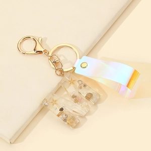Detail of resin letter M keychain featuring mini starfish, seashells, and pearls inside
