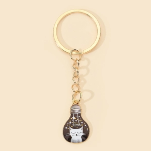Close-up of a creative bulb-shaped keychain featuring a cute white cat and starry sky design