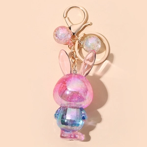 Détail d'un porte-clés lapin en résine dégradé rose et bleu avec fermoir en métal doré