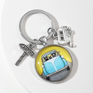 Detailed view of alloy keychain with camping sign and cat driving a car glass pendant