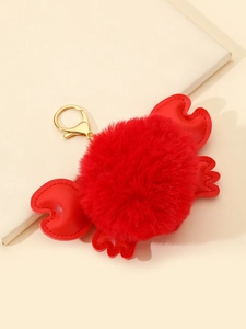 Detailed view of a plush red crab keychain with fluffy pompom body and gold metal clasp