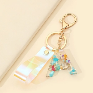 Detailed macro of resin letter A keychain with sea shells, glitter and laser wrist strap