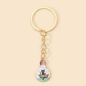 Detail of creative golden keyring with cute cat on a boat lightbulb pendant charm