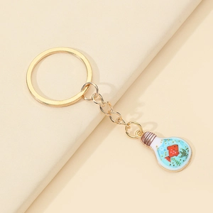 Detail of a golden bulb keychain featuring a miniature red fish and green aquatic plants