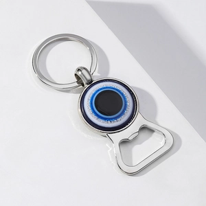 Détail de l'ouvre-bouteille porte-clés en métal œil bleu sur un fond blanc épuré