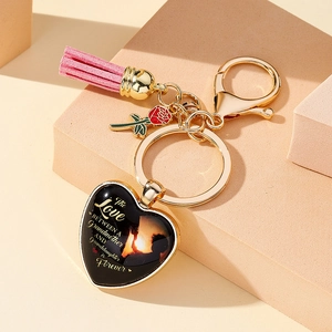 Macro detail of heart locket keychain with pink tassel and rose charm for Mother's Day