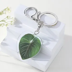 Detail of green leaf heart acrylic keychain with silver metal lobster clasp and ring