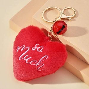 Détail du porte-clés cœur en peluche rouge avec broderie 'So Much' et clochette dorée