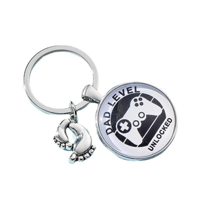 Silver gaming keychain with Dad Level Unlocked pendant and cute baby footprint charms