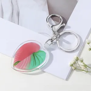 Close-up of heart acrylic leaf pendant with red and green veins on a white background