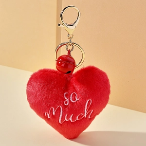 Détail d'un porte-clés cœur en peluche rouge avec broderie so Much et anneau doré