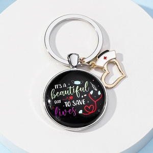 Close-up of nurse keychain with medical icons and it is a beautiful day to save lives text