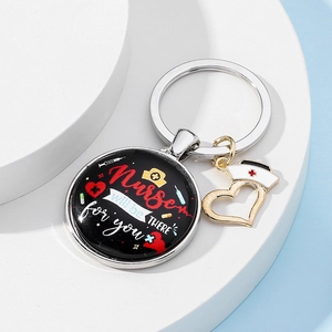 Detail of silver nurse keychain with round pendant featuring medical icons and quote