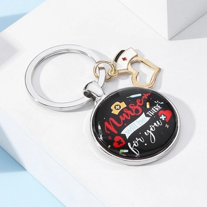 Close-up of nurse keychain with heart charm, cap pendant and motivational quote