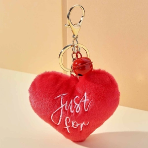 Gros plan du porte-clés en peluche cœur rouge avec broderie Just for et petite cloche