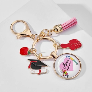 Detail of graduation keychain with pink tassel, red apple charm and teacher thank you message