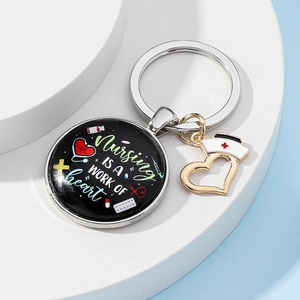 Detail of Nursing is a Work of Heart keychain with stethoscope and nurse hat charms