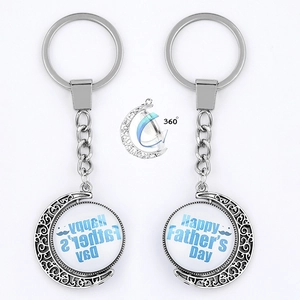 Close-up of a 360-degree rotating Father's Day keychain with a moon-shaped silver frame