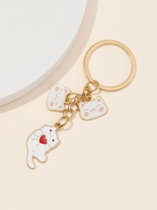 Détail du porte-clés chat mignon avec breloques cœur et anneau doré sur fond beige