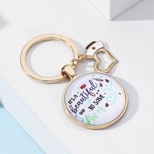 Détail du porte-clés infirmier doré avec pendentif en verre et message inspirant