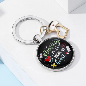 Detailed view of nurse keychain with nursing heart text and medical charms on white stand