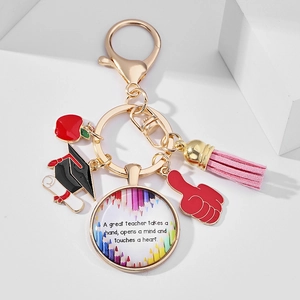 Detail of teacher keychain with red apple, graduation cap, and pink leather tassel pendants