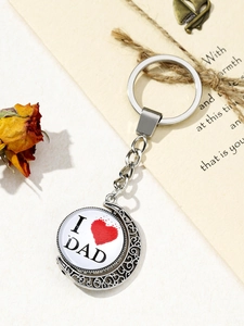 Close-up of silver metal DAD keychain with crescent moon frame and red heart detail