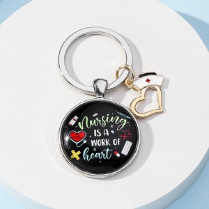 Black nursing theme keychain with heart pendant and medicine symbols on a round tray