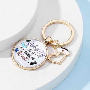 Détail du porte-clés infirmier doré avec citations inspirantes et breloques médicales