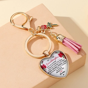 Detail of a heart pendant keychain with rose and tassel, featuring a message for granddaughter