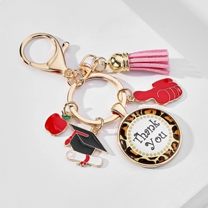 Detailed view of graduation keychain with pink tassel, apple charm, and Thank You pendant