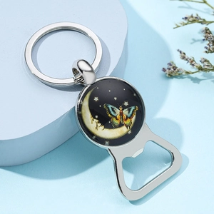 Polished silver bottle opener keychain with moon and butterfly design on blue background