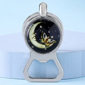 Close-up of silver metal bottle opener keychain with celestial moon and butterfly charm