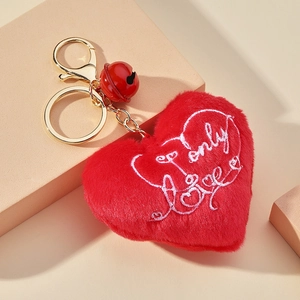 Détail du porte-clés cœur en peluche rouge avec broderie only Love et clochette dorée