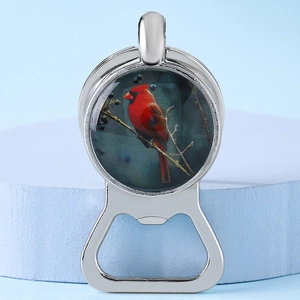 Macro detail of silver metal bottle opener with a cardinal bird glass dome pendant