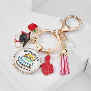 Detail of Best Teacher Ever keychain with enamel charms on a clean white display