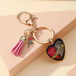 Détail du porte-clés commémoratif en cœur avec pompon rose et breloque rose rouge