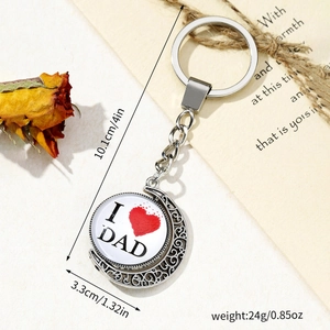 Father's Day silver keychain with rotating I Love Dad pendant on a rustic desk background
