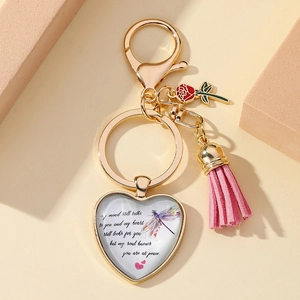 Detail of heart pendant keychain with pink tassel, red rose and dragonfly illustration